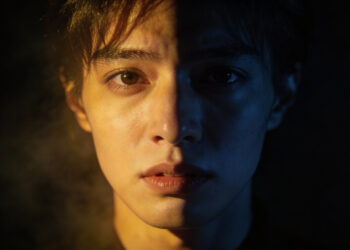 a character face with split lighting, half in warm light and half in shadow, representing moral ambiguity.