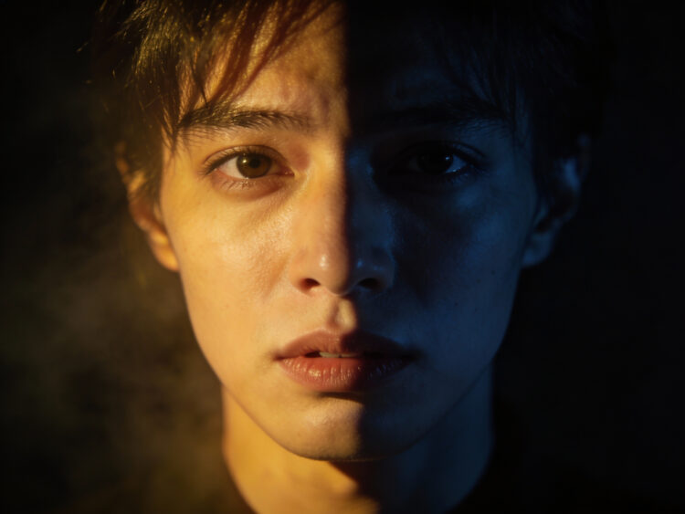 a character face with split lighting, half in warm light and half in shadow, representing moral ambiguity.