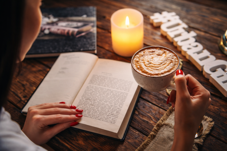 Cozy reading moment with coffee and book on sunlit table creating inviting atmosphere