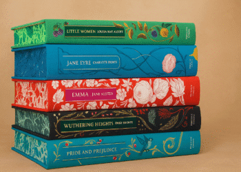 Stack of classic literature books including Pride and Prejudice, Jane Eyre, Emma, and Wuthering Heights with ornate vintage covers