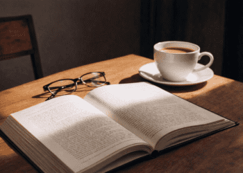 Atmospheric close-up of open book with candlelight and warm lighting, evoking the emotional intensity of cliffhanger-driven reading
